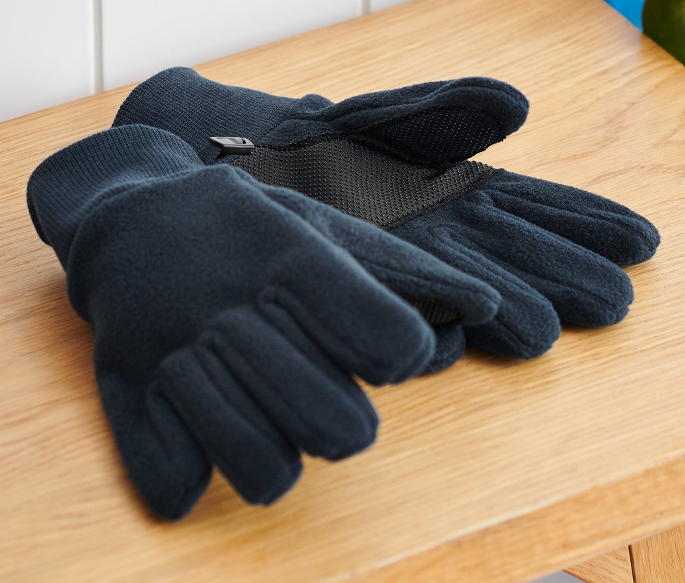 A fa padon gyerek polárkesztyű van egy hátizsák és egy gördeszka mellett.