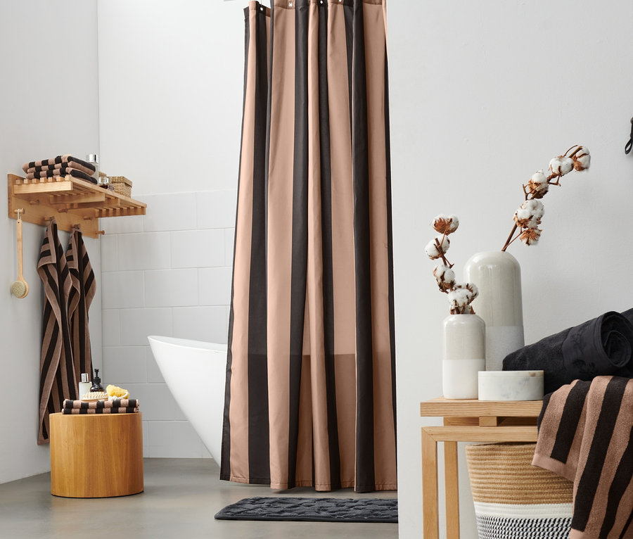 A fürdőszobában létra van fekete-barna virágmintás törölközővel, ablak, kosár, textil függöny, két fekete prémium törölköző, egy fekete-barna csíkos, kiváló minőségű fürdőlepedő és bézs prémium törölközők.