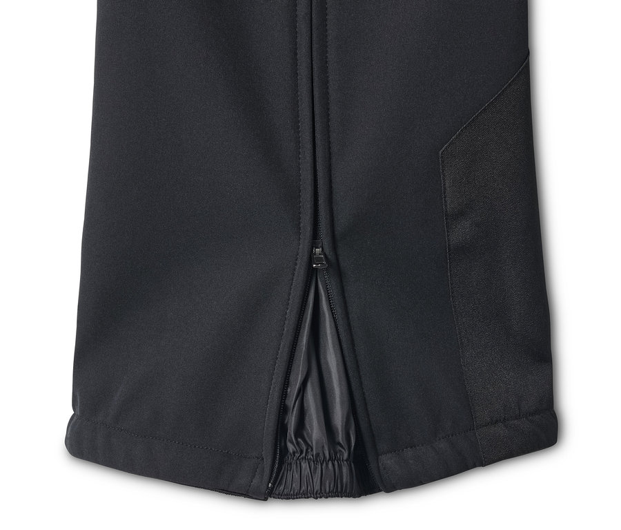 Egy fekete női softshell jet sínadrág részlete cipzárral a bokánál.