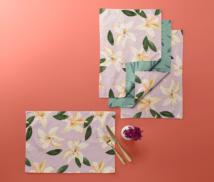 Négy kétoldalas, virágmintás tányéralátét korall színű háttéren.