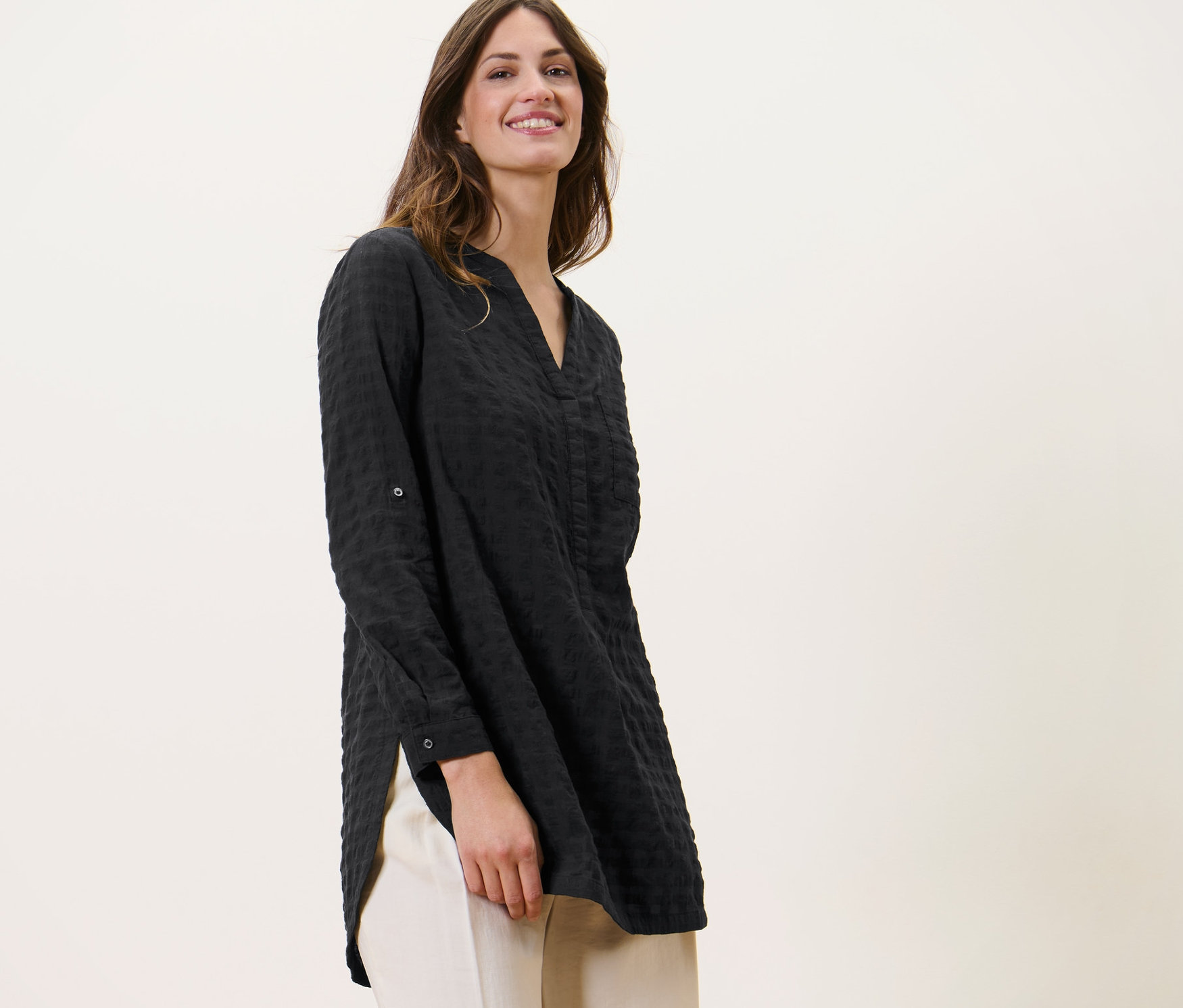 Nő visel szövött, strukturált hosszú tunikát és világos nadrágot.