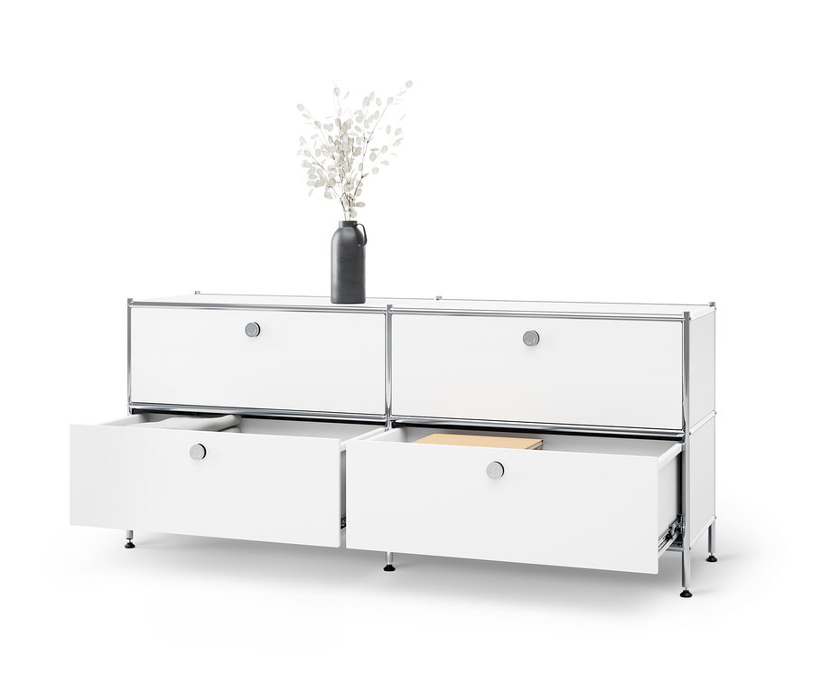 Fehér »CN3« alacsony fém komód 4 fiókkal, melyből kettő nyitva van. A komódon egy váza áll fehér ágakkal.