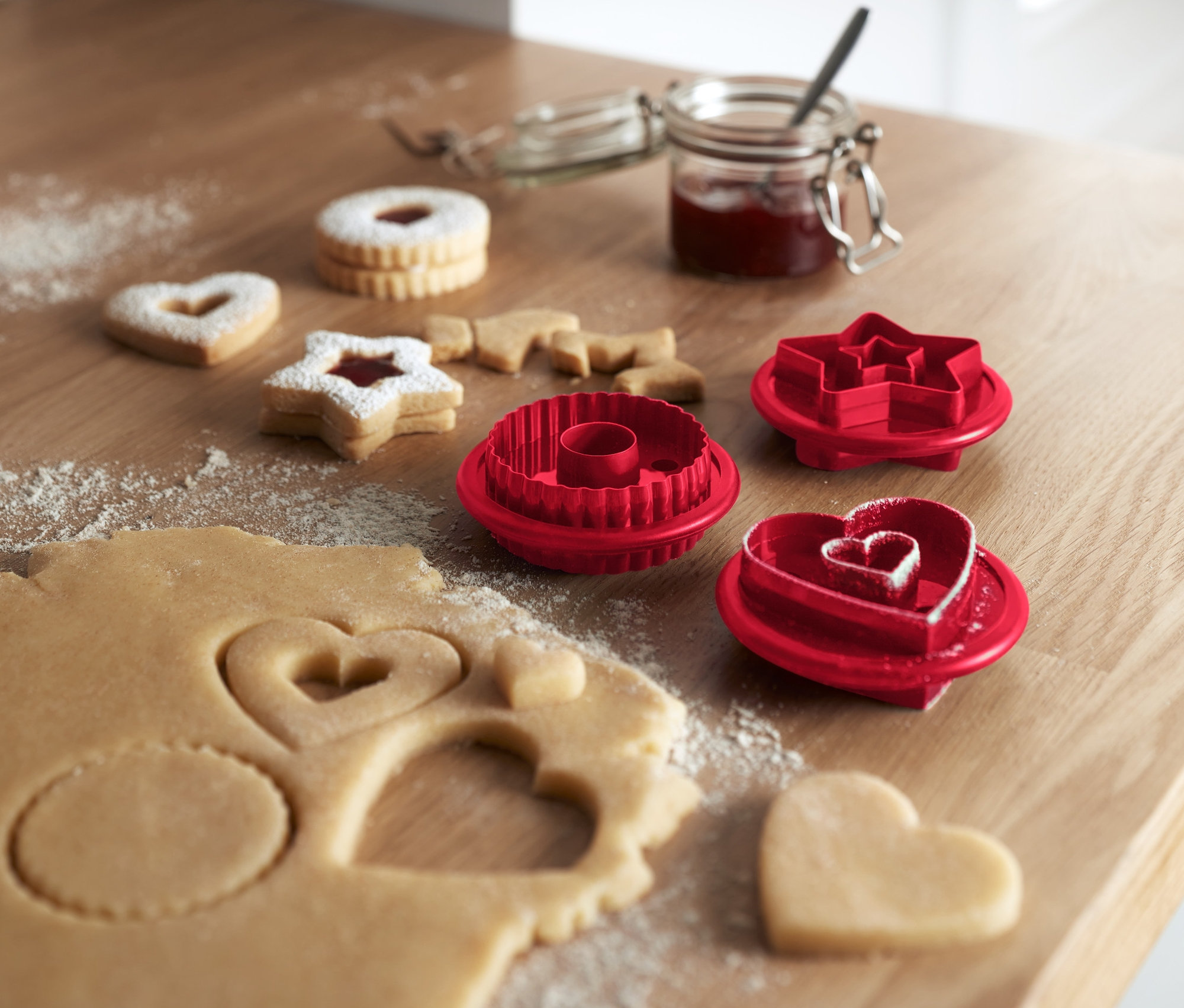 Egy fa asztalon linzerek és egy 3 darabos linzerkiszúró szett található.