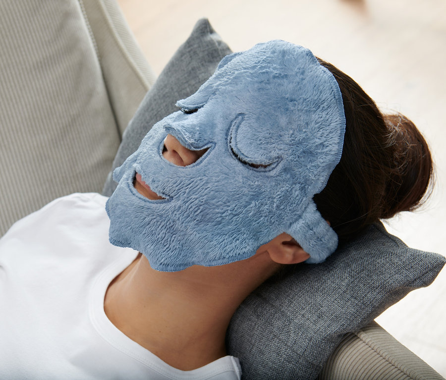 Nő fekszik a párnán kék 2 arcmaszk, világoskék/sötétkék színben.