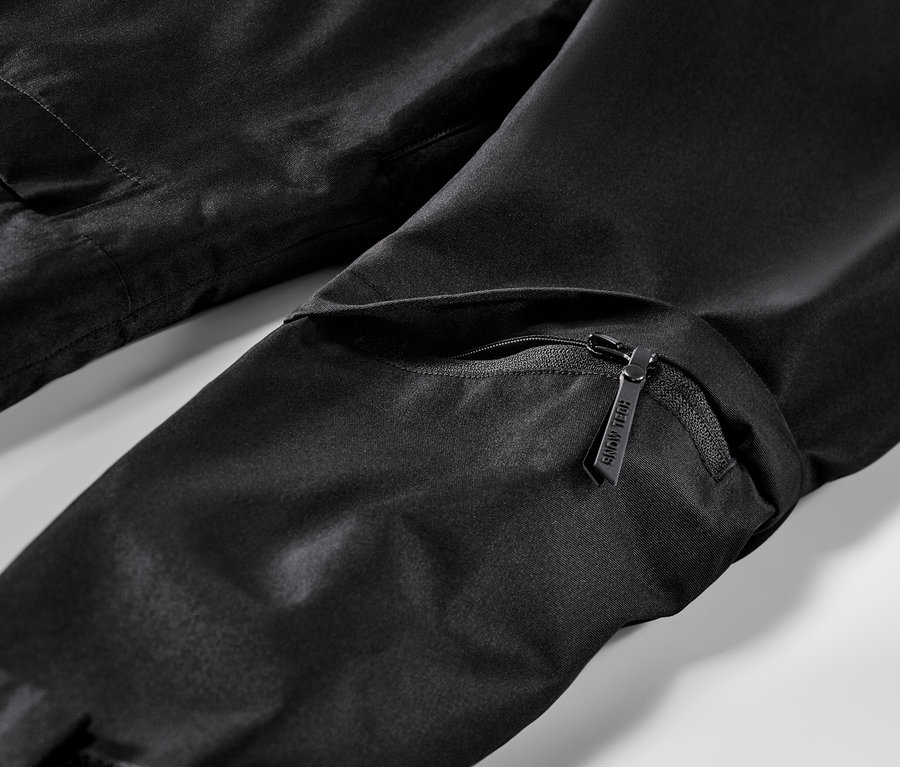Egy fekete síkabát részlete cipzárral és zsebbel.