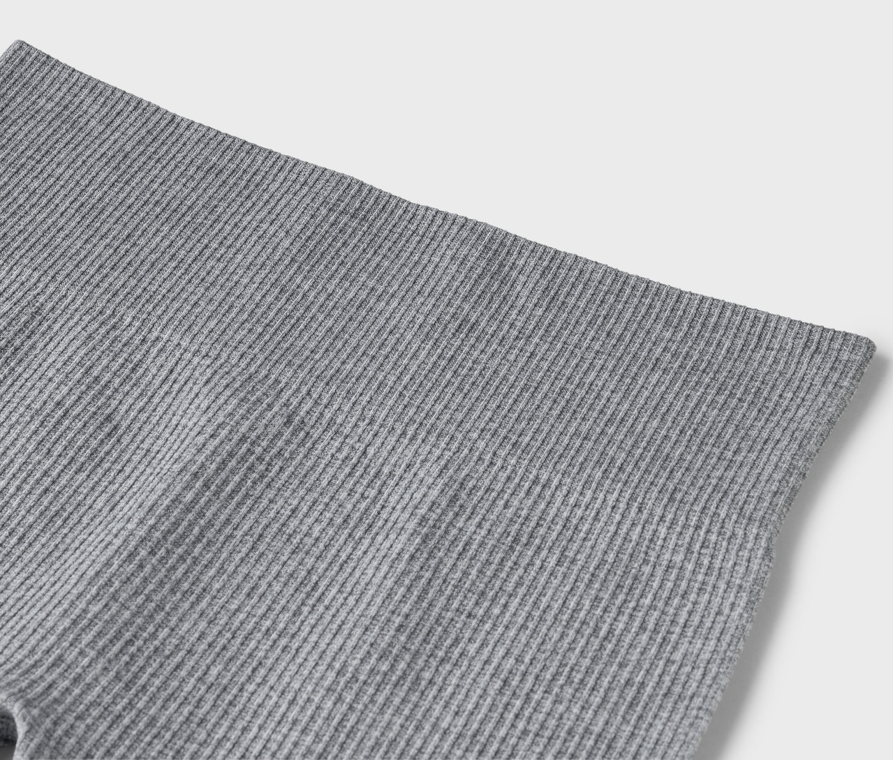 Egy szürke, bordázott leggings közeli képe.