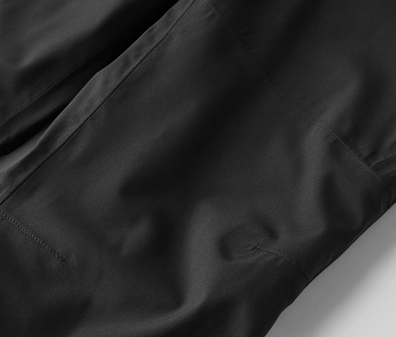 Egy fekete nadrág részletének közeli képe.