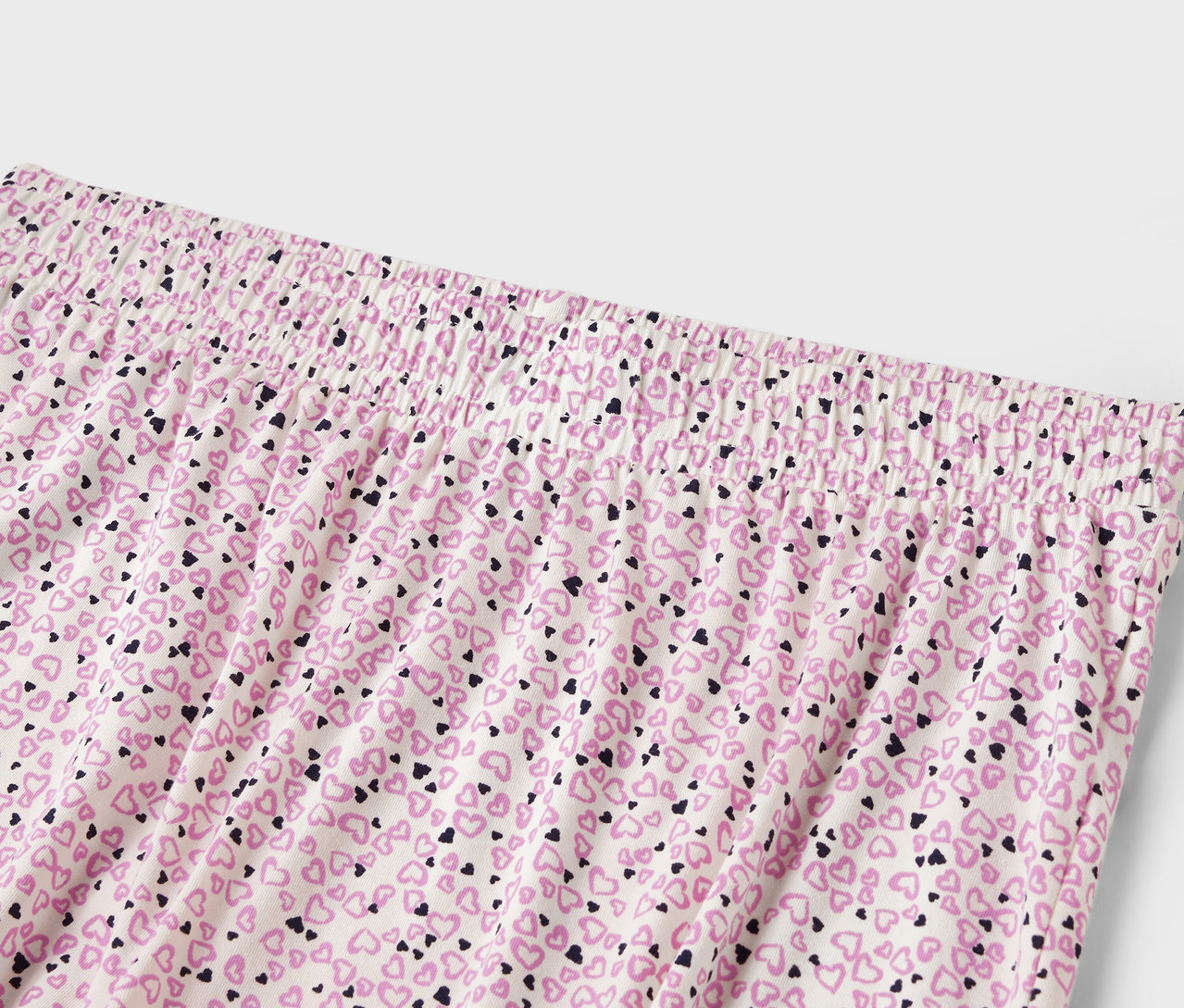 Egy női nadrág részlete, gumis derékpánttal és apró szívecskés mintával.