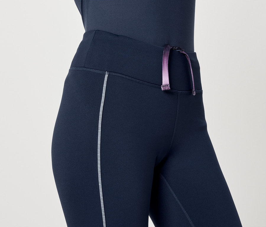 Női, sötétkék leggings részlete, lila húzózsinórral.