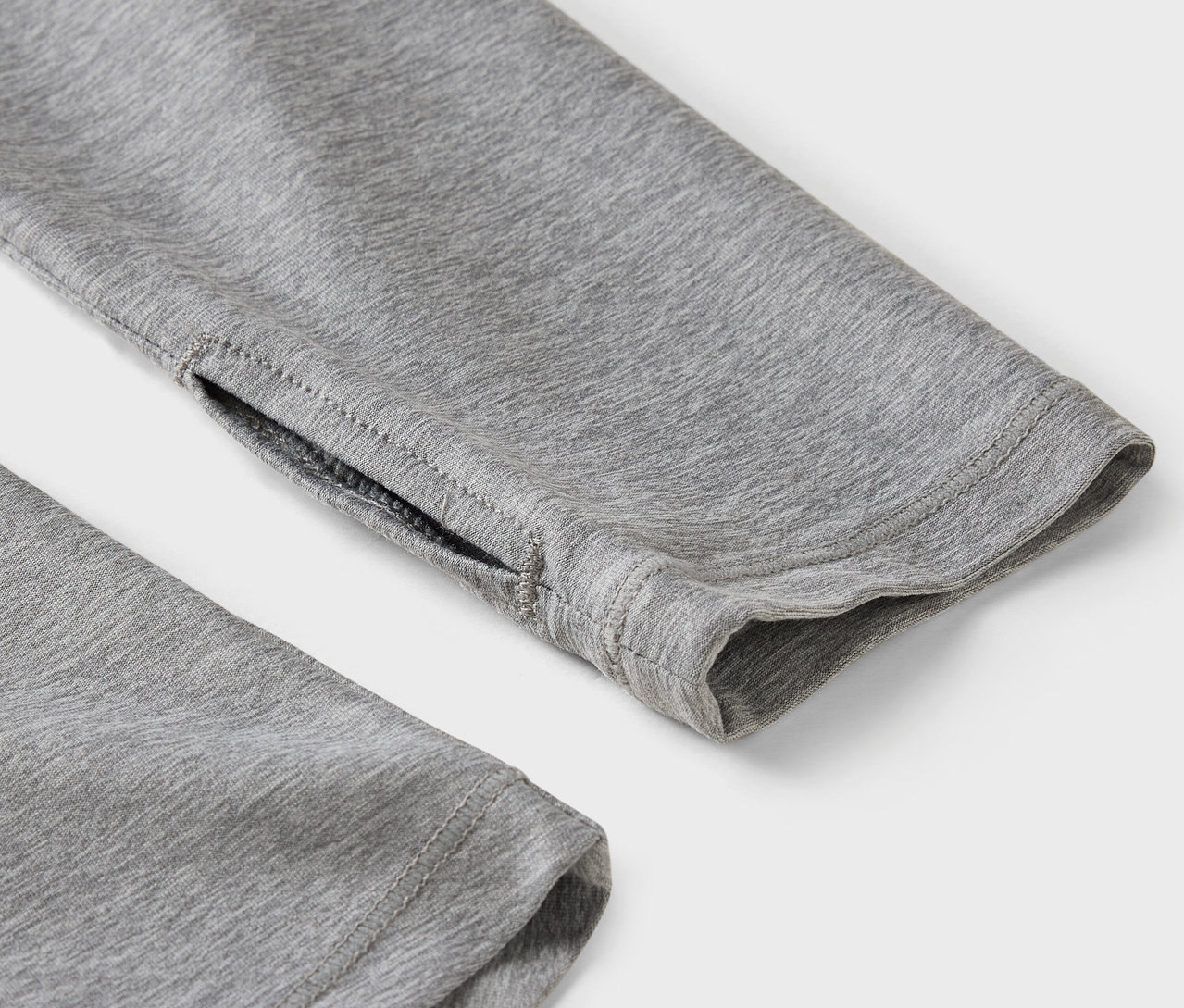 Egy szürke ujj részlete hüvelykujj-bújóval.