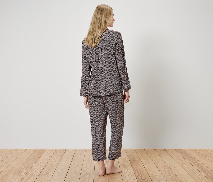 Hátulnézet egy mintás, hosszú ujjú pizsamát viselő nőről.