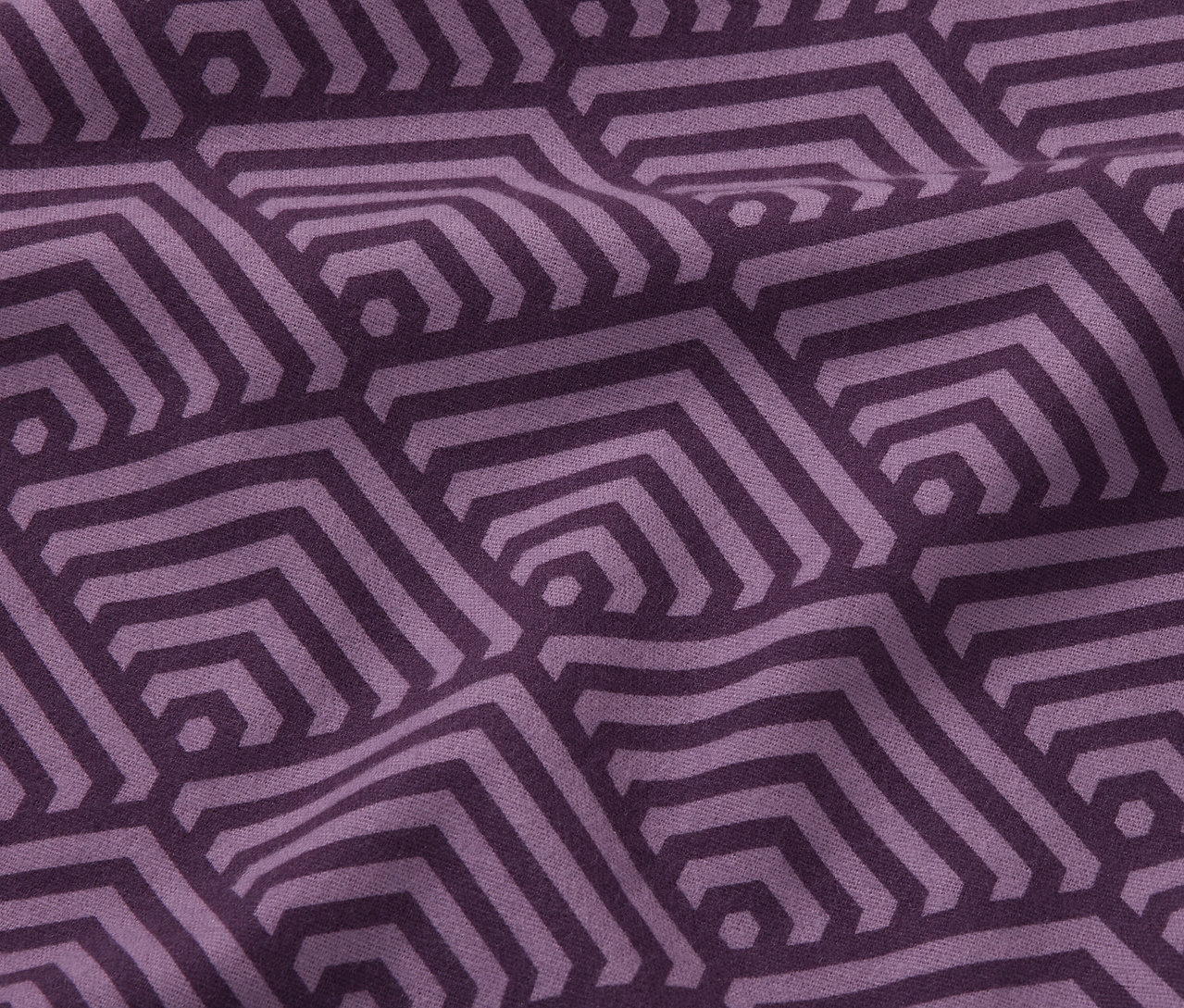 Közeli kép egy lila, normál méretű pamutflanel ágyneműről, geometrikus mintával.