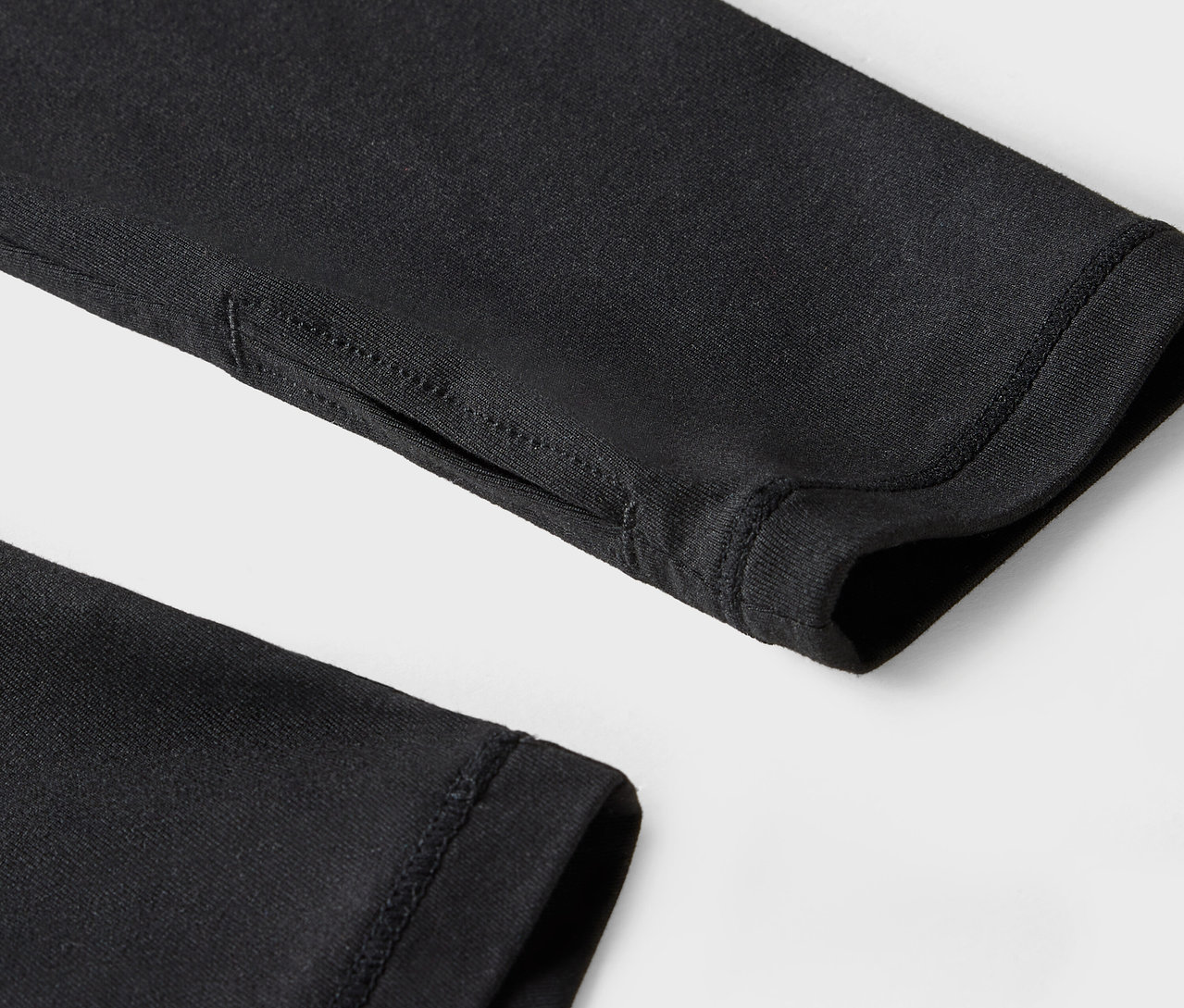 Egy fekete ujj részlete hüvelykujj lyukkal.