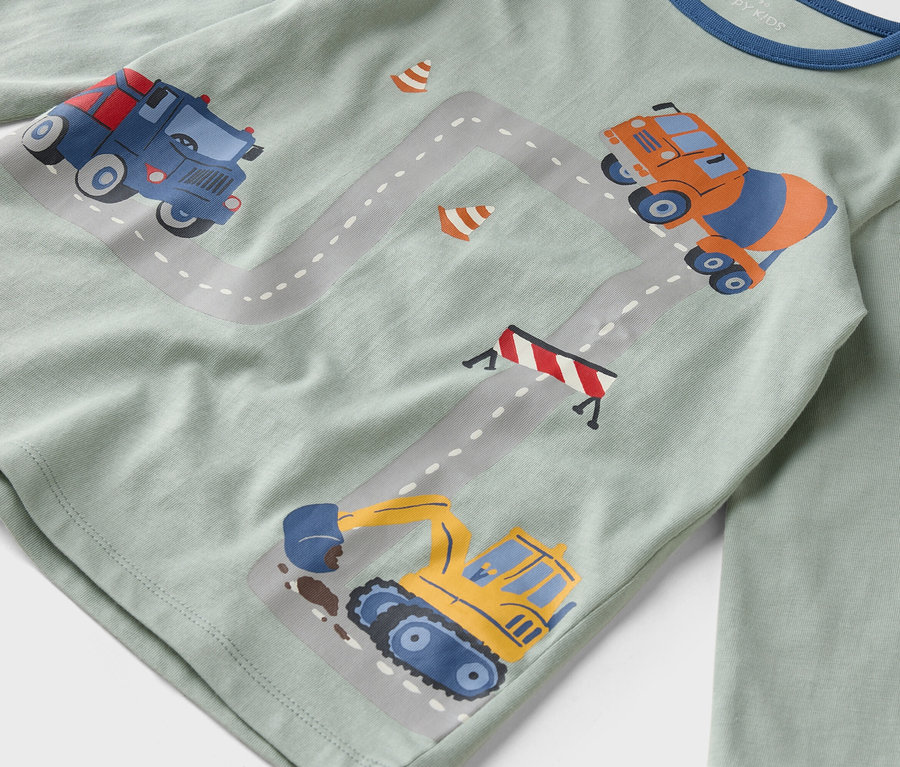 A világoszöld ingre építőipari járművek illusztrációi vannak egy szürke úton.