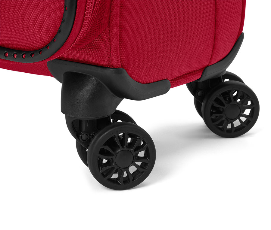 Egy piros bőrönd fekete kerekeinek közeli képe.