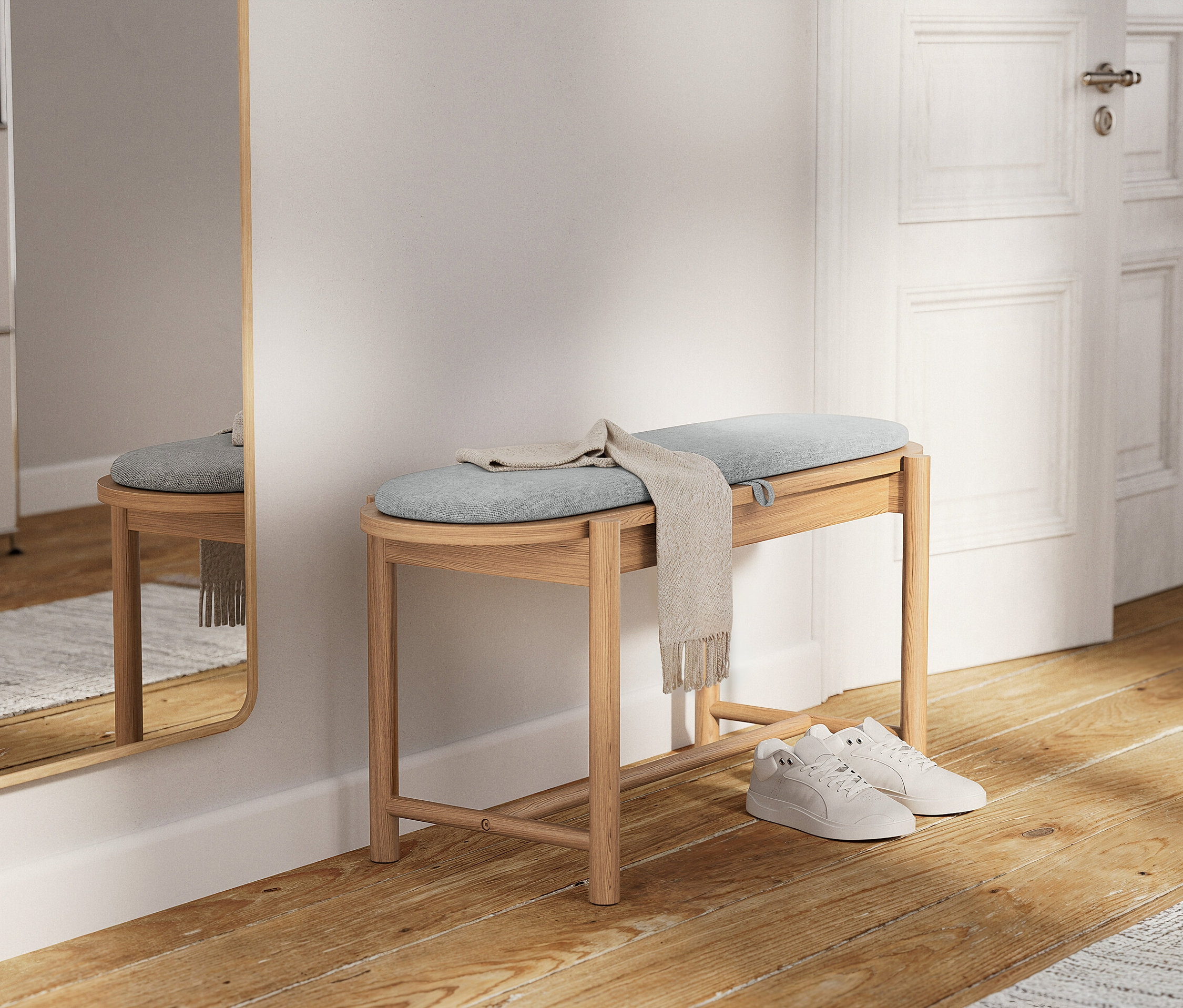 Egy világos fa pad világoskék párnával és egy bézs színű sállal. Alatta fehér tornacipők vannak.