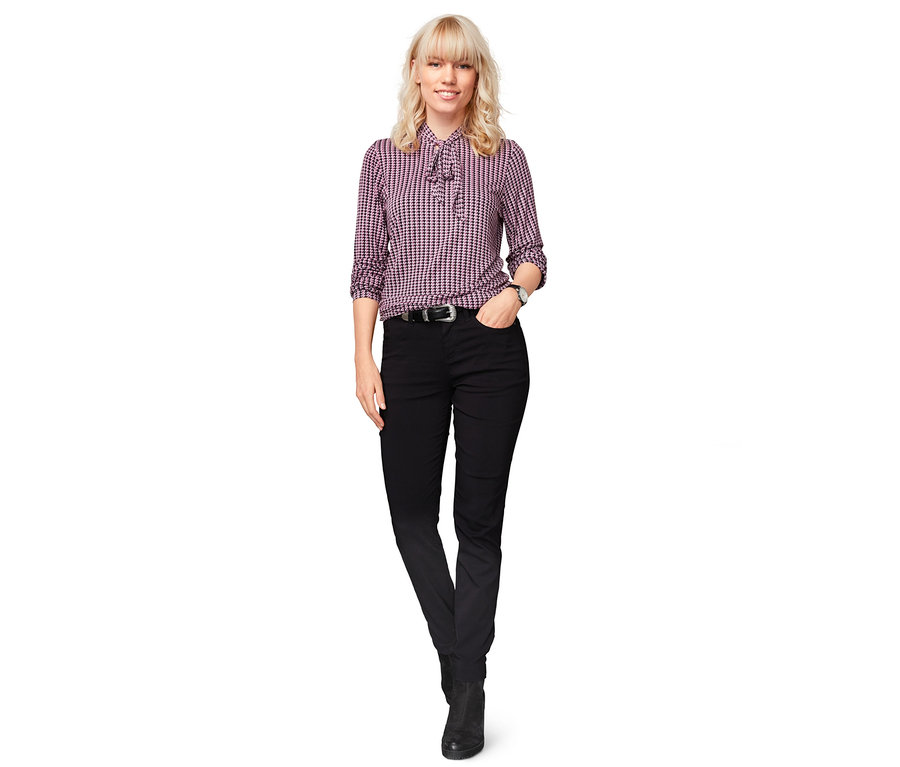 Nő áll fekete, női bengalin termonadrágot viselve.