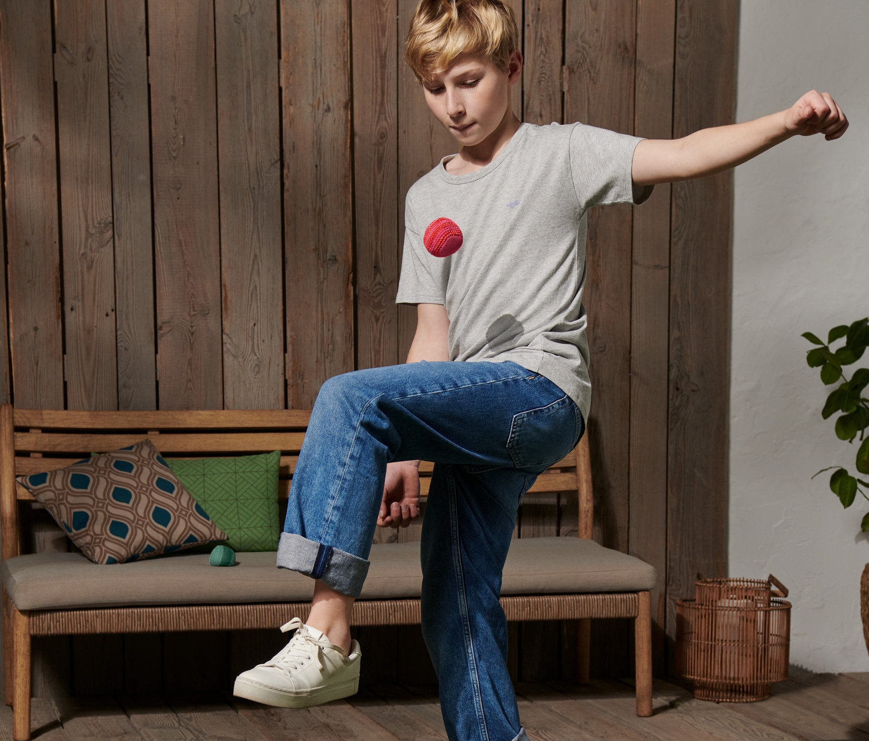 Egy fiatalember a zöld gyepen rúgja a 2 horgolt footbag labda egyikét.