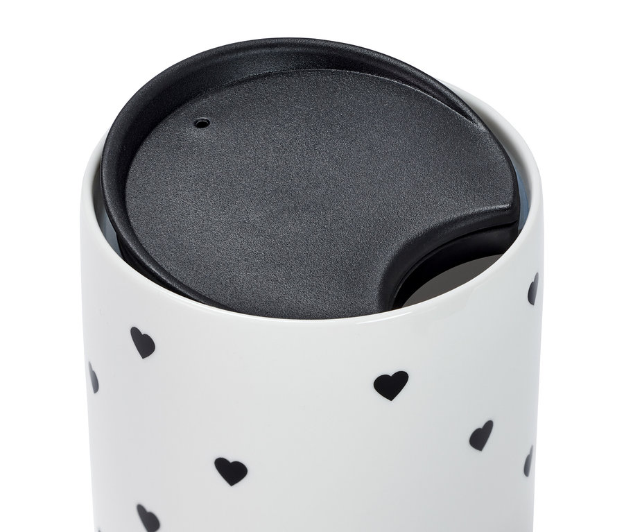 Egy porcelánbögre részlete fekete szívecskékkel és fedéllel.