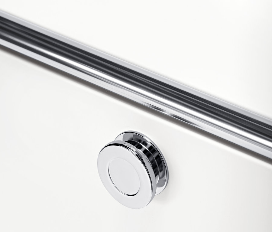 Közelkép egy fehér CN3 görgős tárolókról, króm fogantyúval és kerek gombbal.