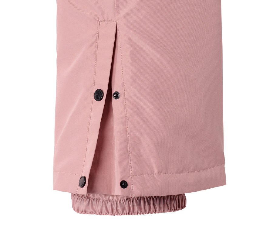 Egy rózsaszín sí- és snowboard nadrág részlete patentokkal és gumírozott szegéllyel.