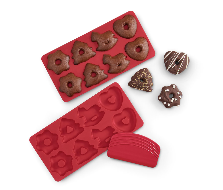 Két piros mini mézeskalács sütőforma, az egyik tésztával töltve, és négy kész mézeskalács.