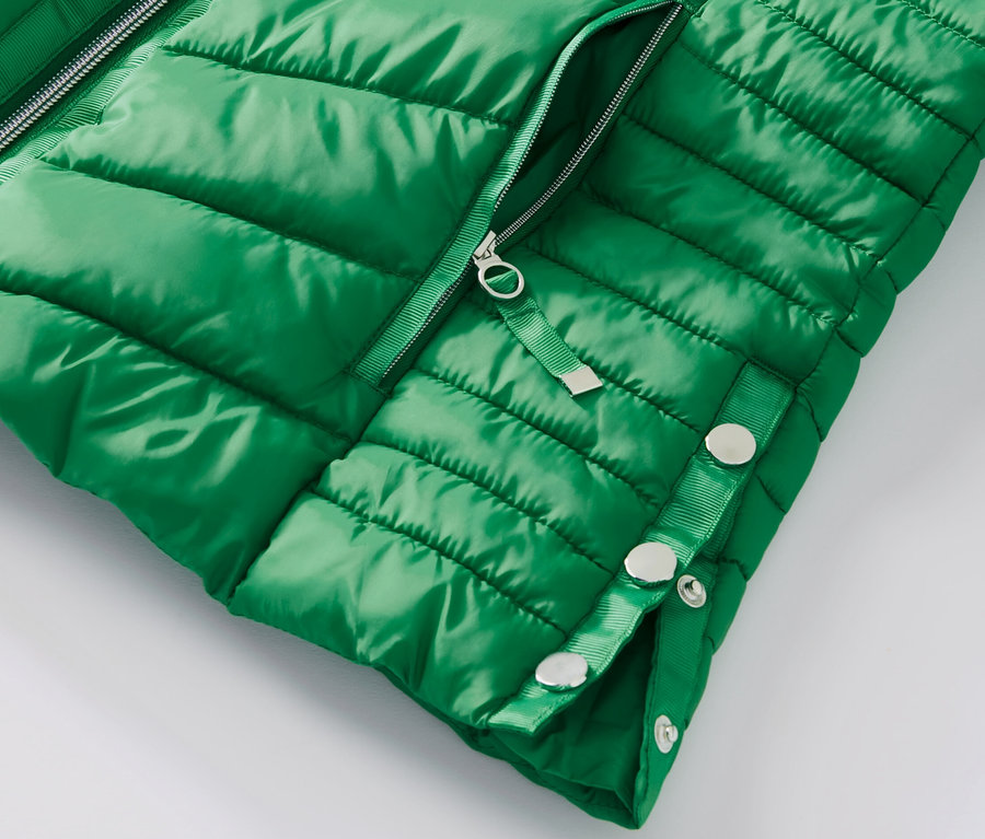 Egy zöld, női steppelt dzseki részlete.