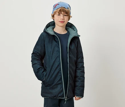 Fiú 2 az 1-ben gyermek softshell és steppelt kabátot visel.