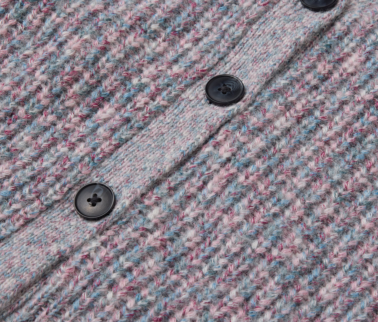 Egy RWS minősített gyapjúból készült kötött gyerekkabát részlete, gombokkal.