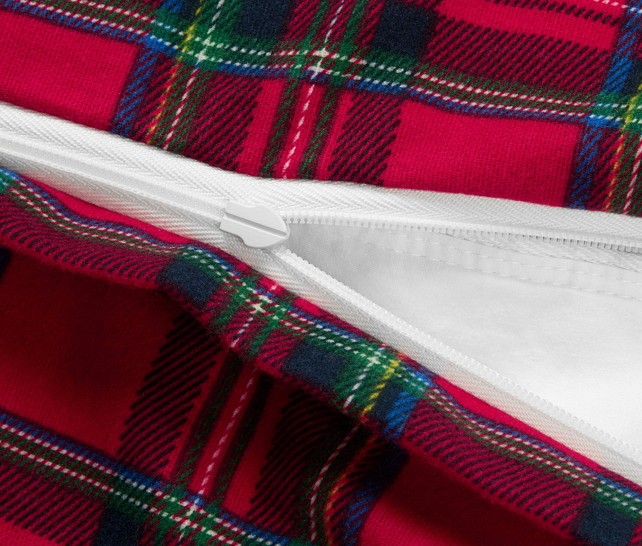 Egy piros, kockás mintázatú paplanhuzat részlete, cipzárral.