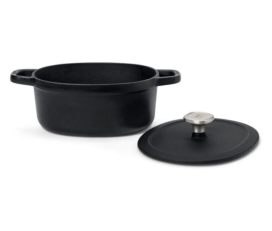 Fekete öntöttvas edény fedővel, fehér háttérrel.
