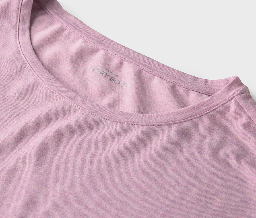 Egy rózsaszín, kerek nyakú póló részlete.