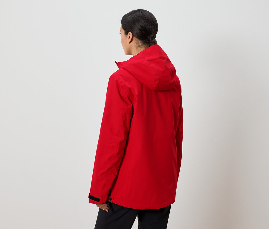 Egy nő háttal áll a kamerának, piros, kapucnis kabátot visel.