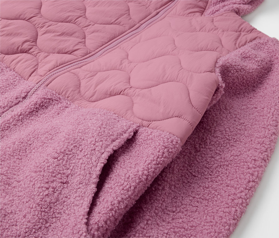 Egy rózsaszín, kapucnis kabát részlete, zsebbel.