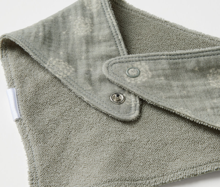 Egy muszlin kendő részlete babáknak, patentokkal.