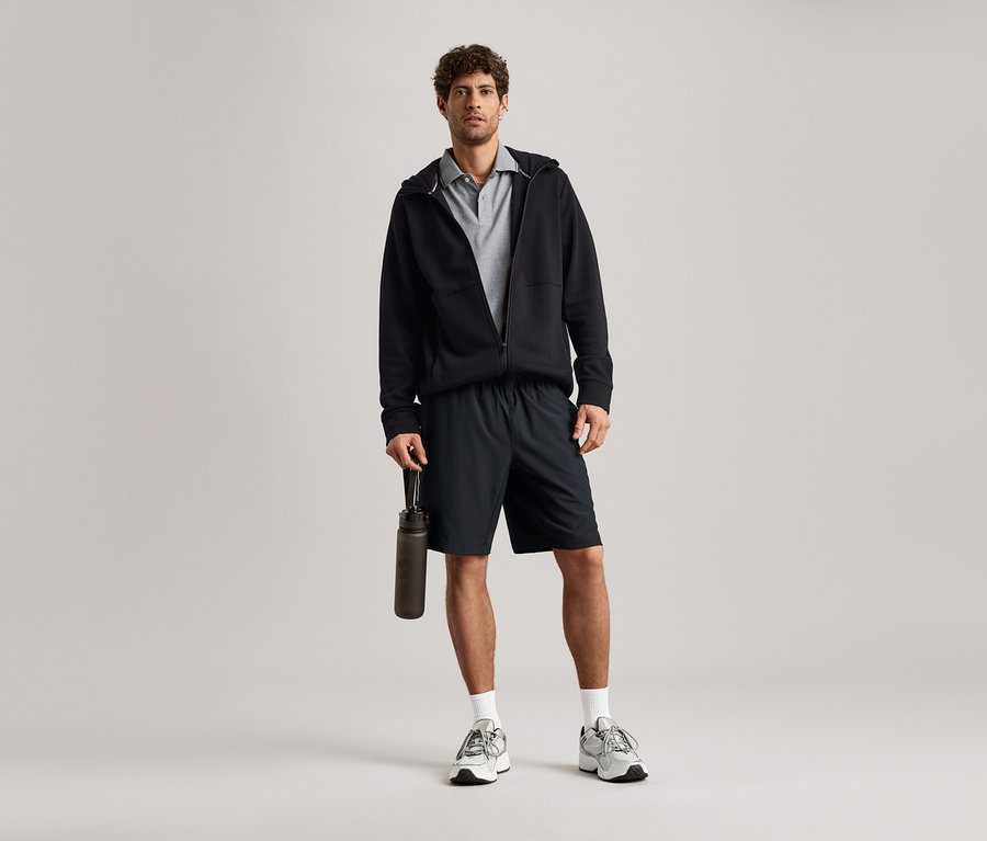 Férfi fekete szabadidőfelsőben és vizes palackkal