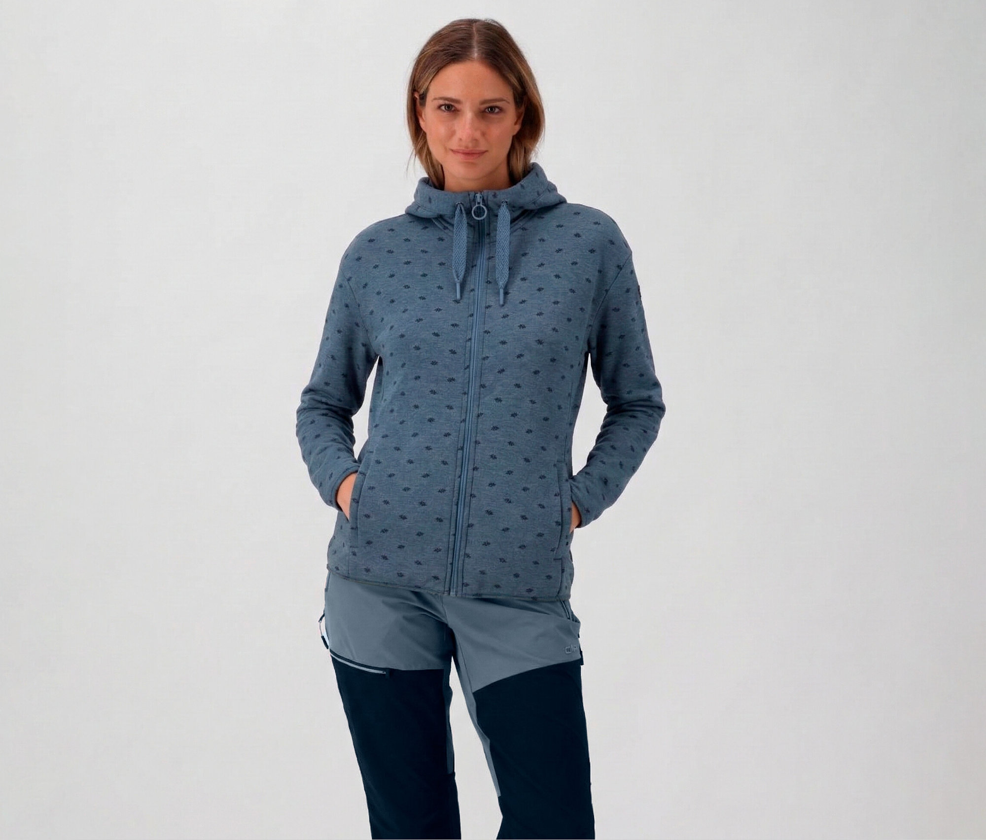 Kapucnis nő kék CMP női polárfelsőben kapucnival, kezével a zsebében.