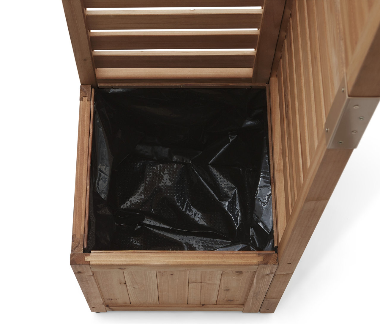 Betekintés egy fekete műanyag béléssel ellátott fa virágládába.