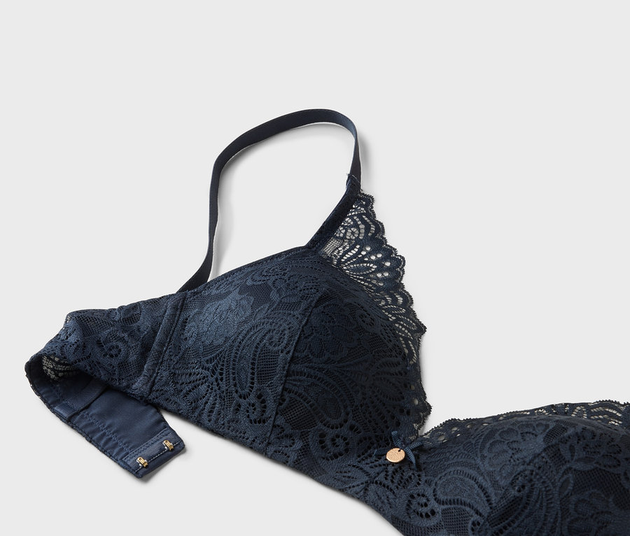Közeli kép egy sötétkék csipkés melltartóról állítható pánttal.