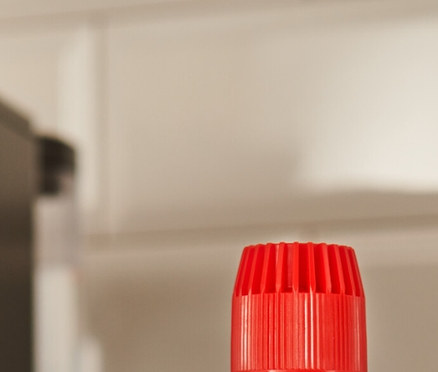 Egy fekete durgol® speciális vízkőmentesítő, 400 ml-es flakon áll a pulton egy kávéfőző mellett.
