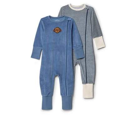 Két babaruha fekszik egymás mellett. Az egyik kék, bársonyos, oroszlánfej folttal, a másik kék-fehér csíkos, krémszínű mandzsettával.