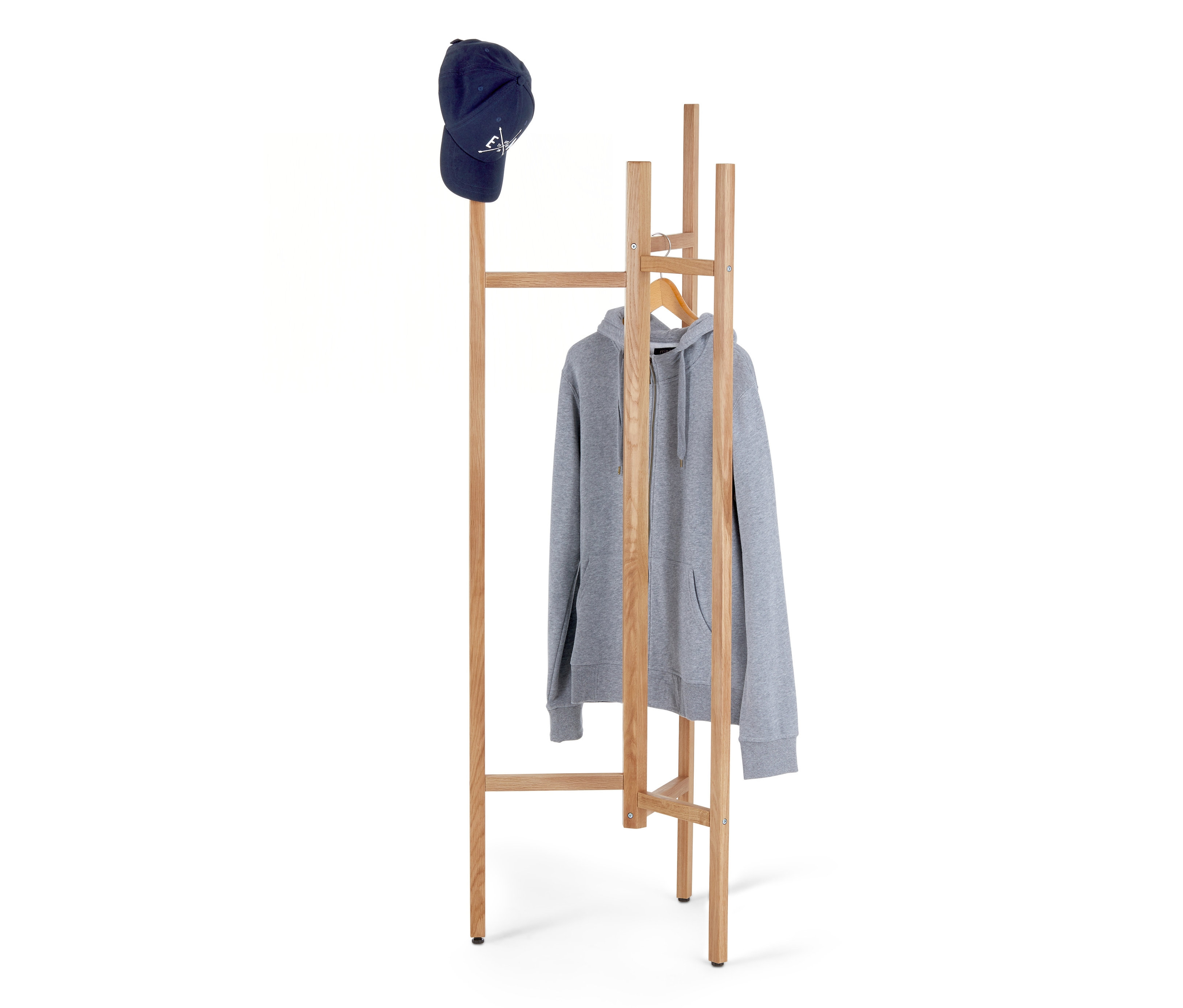 Egy kék baseballsapka egy fa fogason fekszik, amelyen egy szürke, cipzáras kapucnis pulóver lóg.