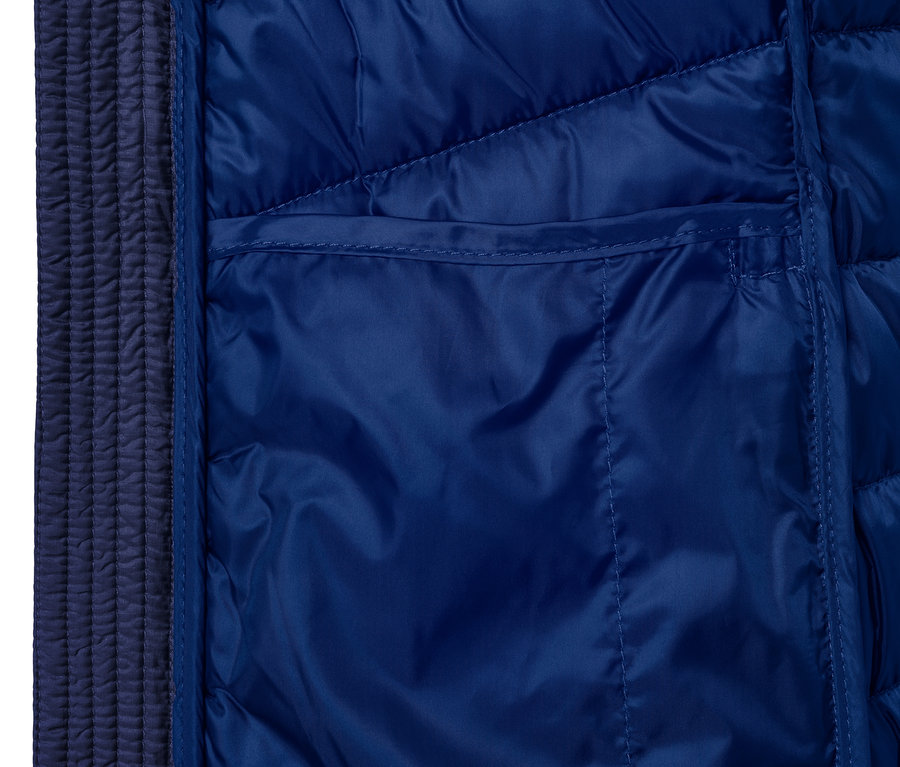 Kék, könnyű steppelt kabát részlete zsebbel.