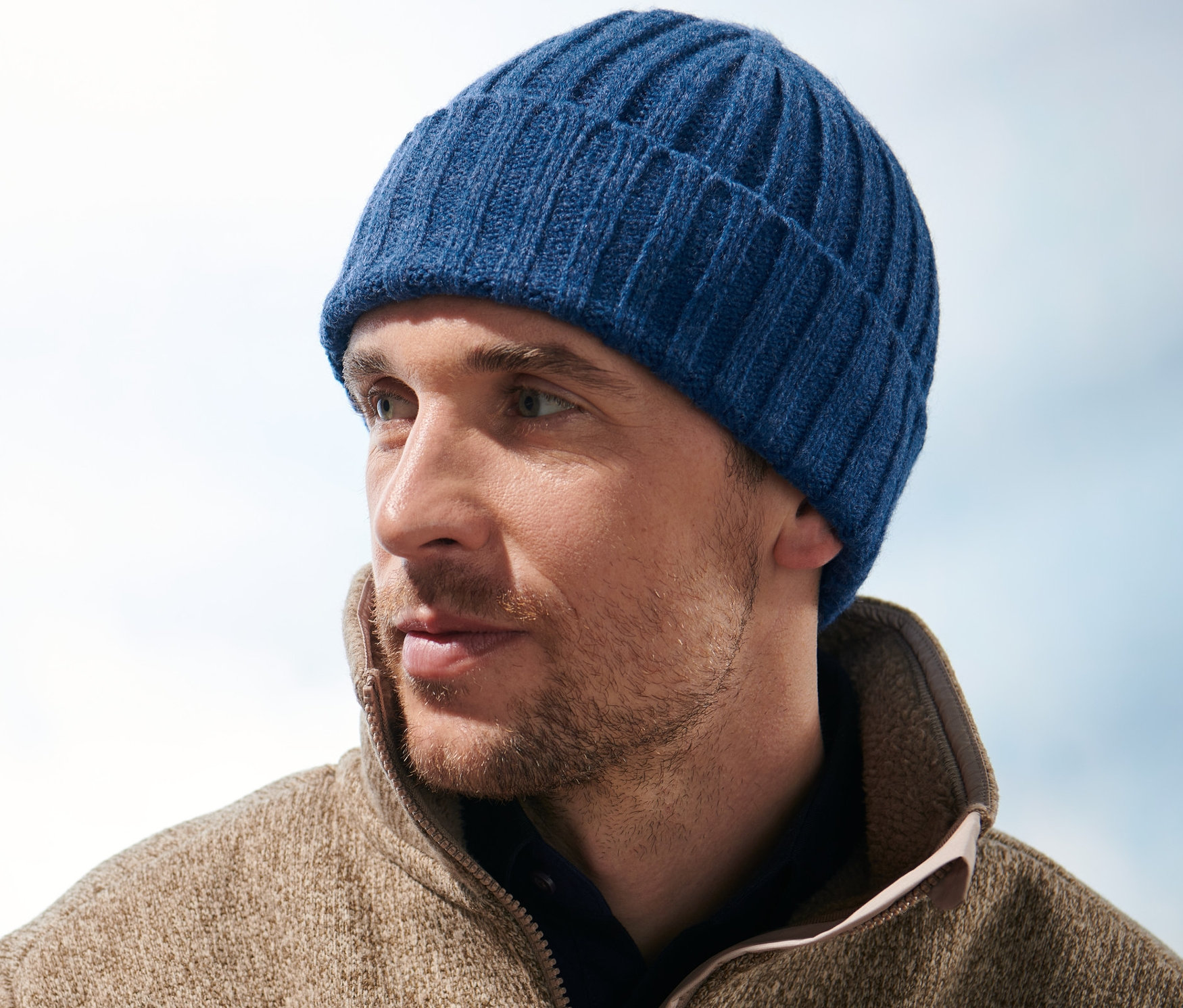 Férfi kötött sapkában jobbra néz.