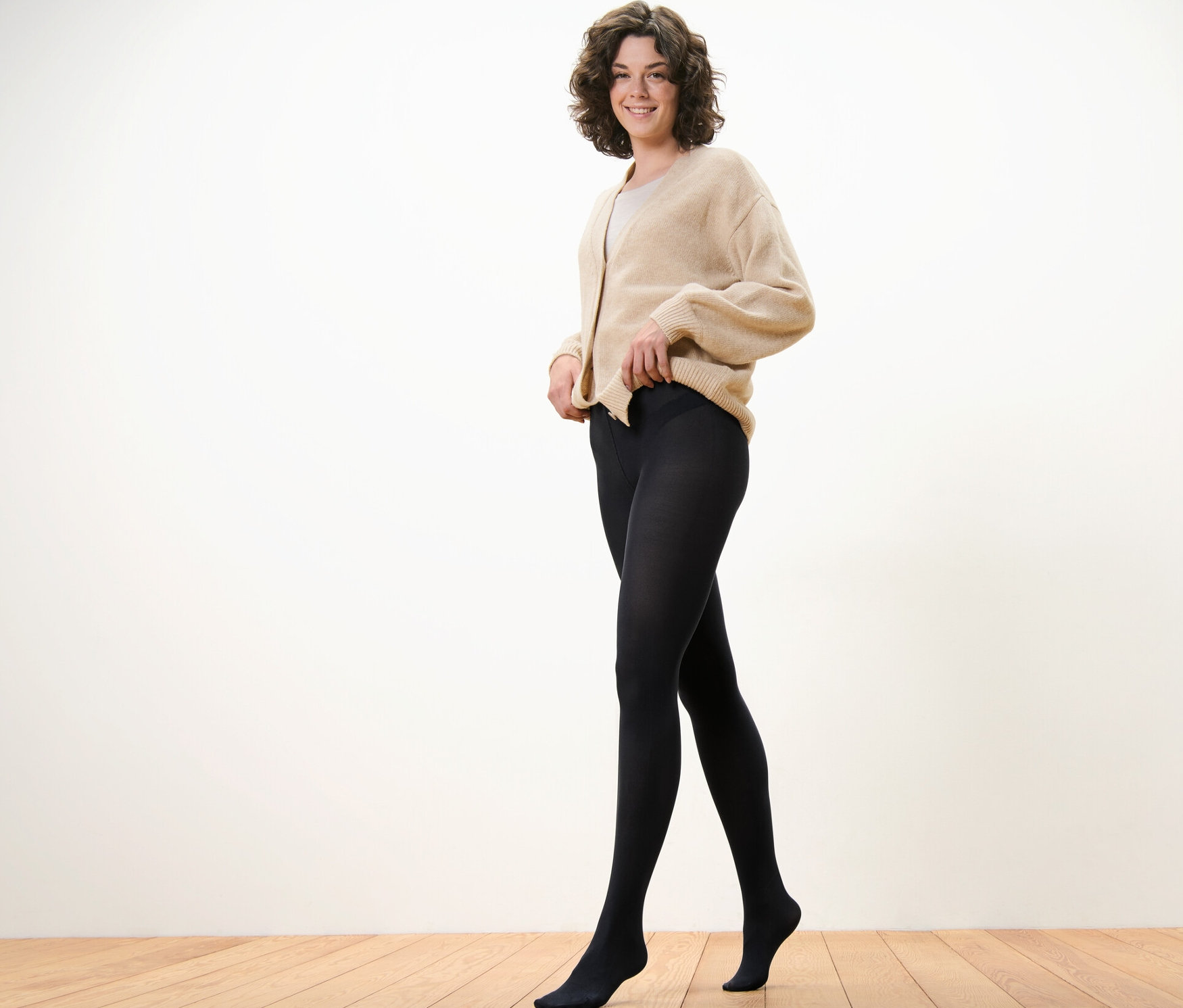 Nő igazgatja a fekete, 80 DEN-es harisnyáját.