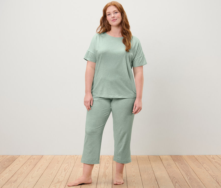 Nő visel egy menta színű, 7/8-os női pizsamát.