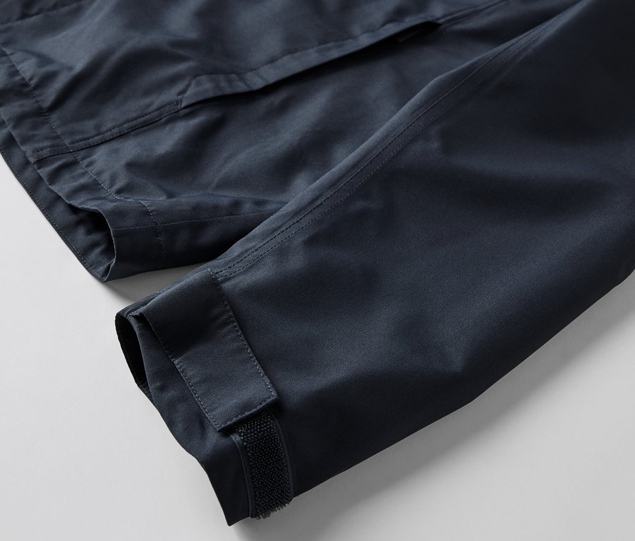 Egy férfi funkcionális parka kabát részlete, a kabát ujja és egy zseb látható.