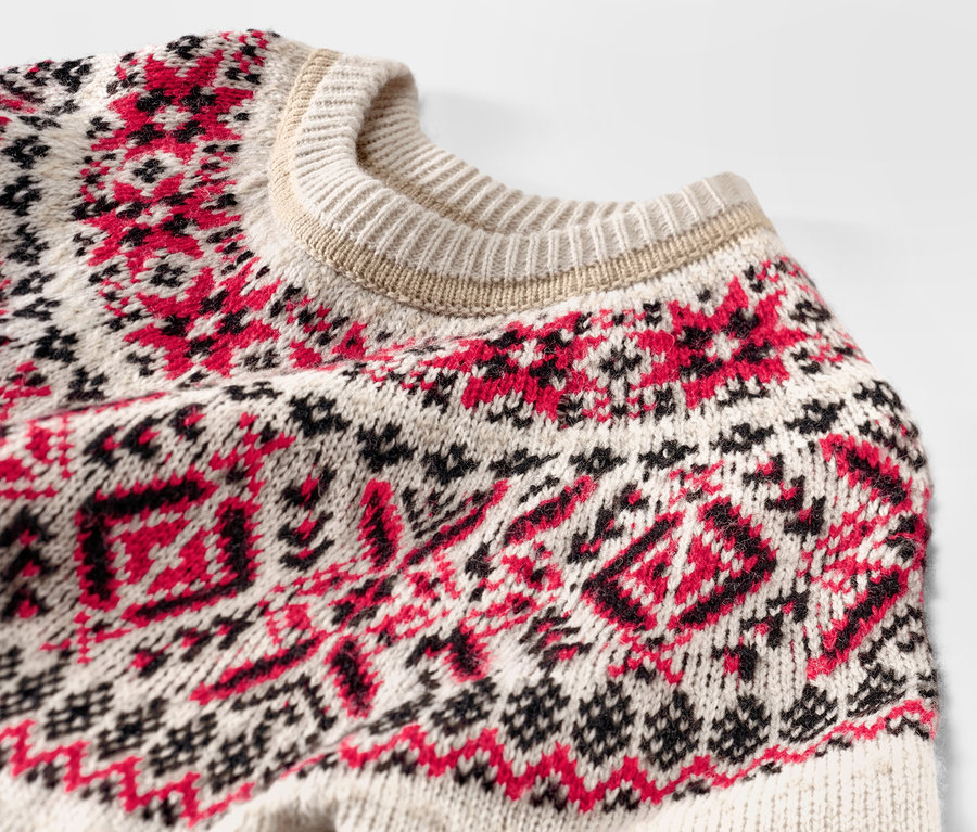 Egy norvég mintás gyerek kötött pulóver részlete.