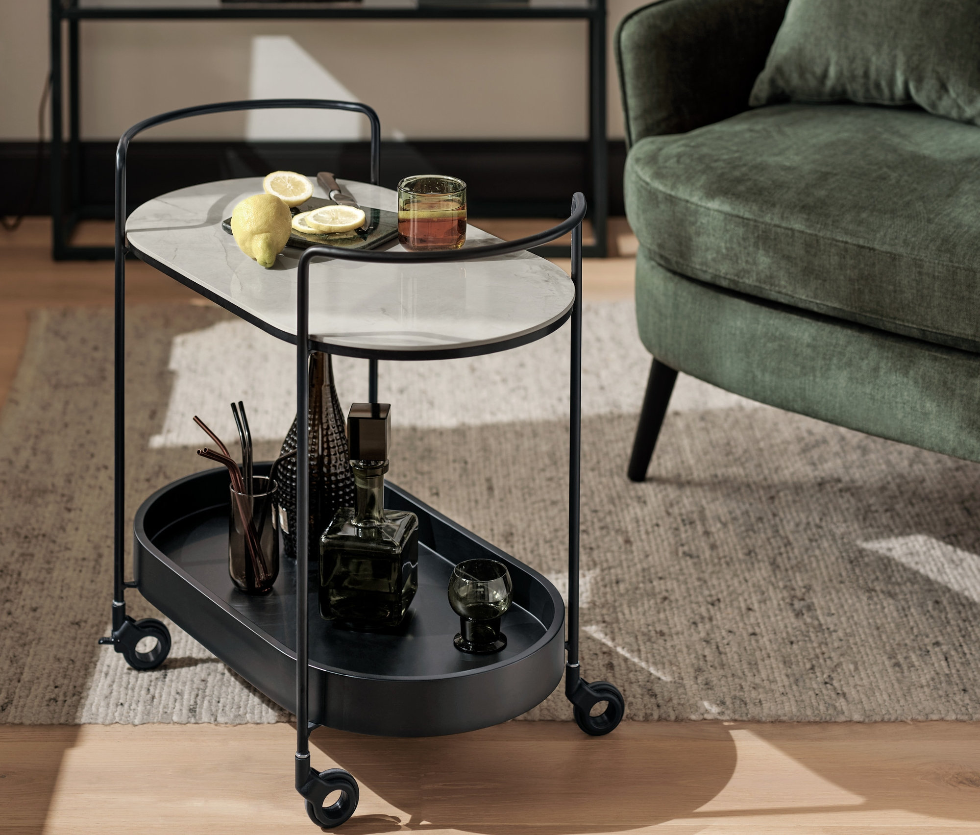 Fekete bárkocsi márványlappal, italokkal és poharakkal. A háttérben márvány hatású konzolasztal és asztali lámpa, füstölt üveg.