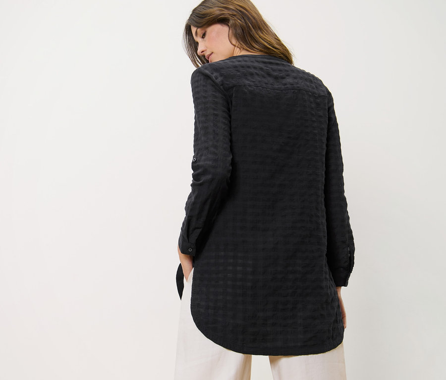 Nő visel szövött tunikát és nadrágot.